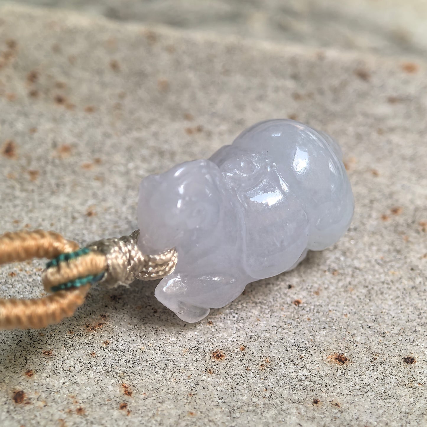 Close-up of fine glutinous white-lavender jadeite Tang Horse pendant showing smooth carved details.
