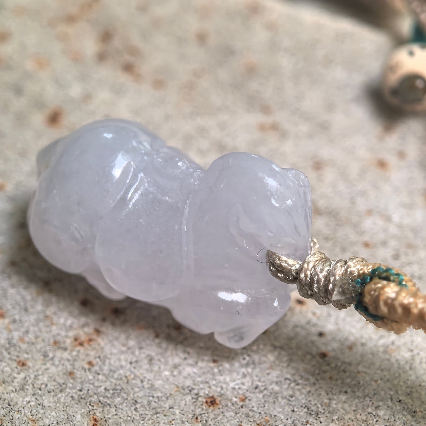 Side view of three-dimensional Tang Horse jadeite pendant with soft pale lavender luster.
