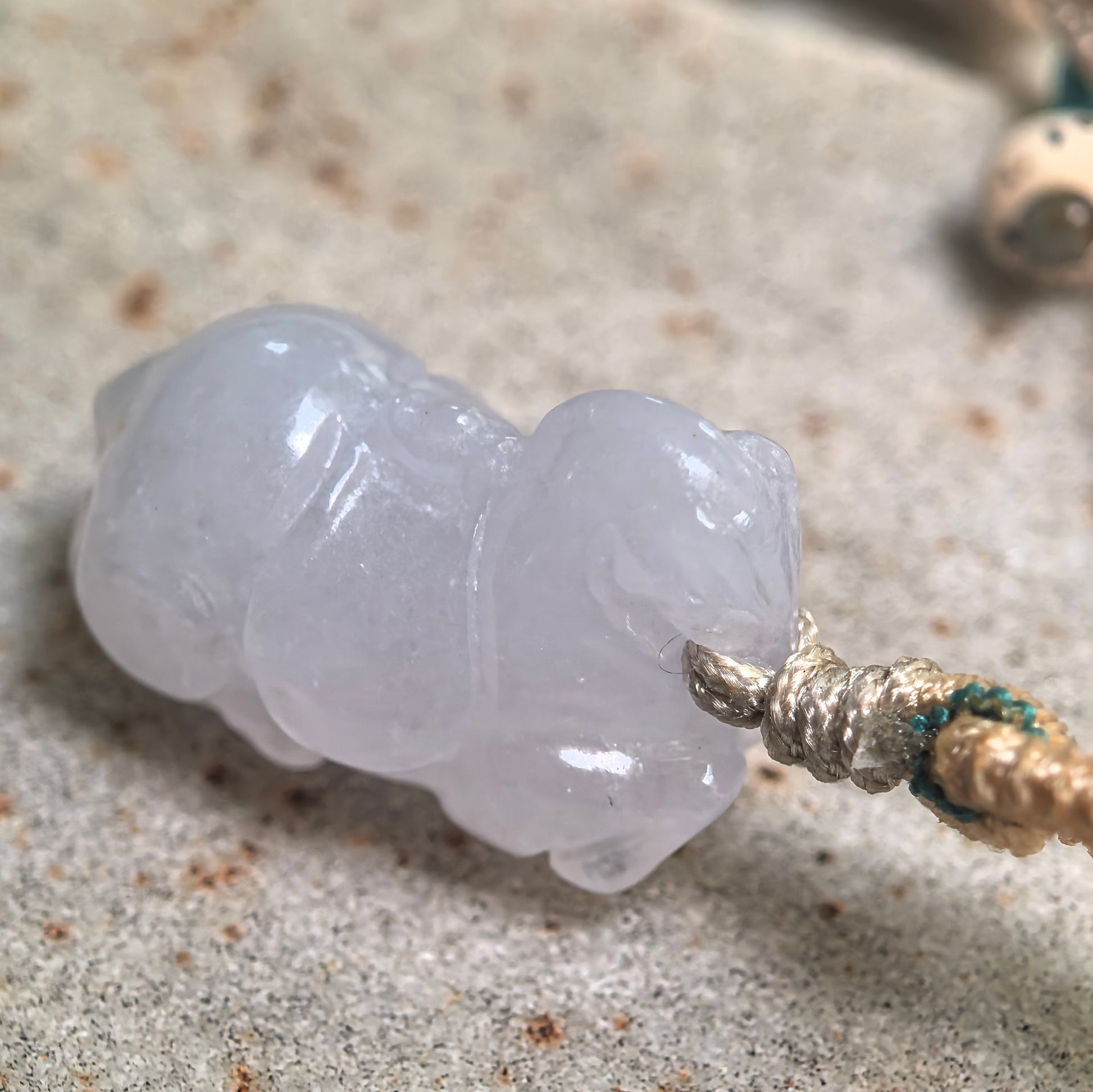 Side view of three-dimensional Tang Horse jadeite pendant with soft pale lavender luster.
