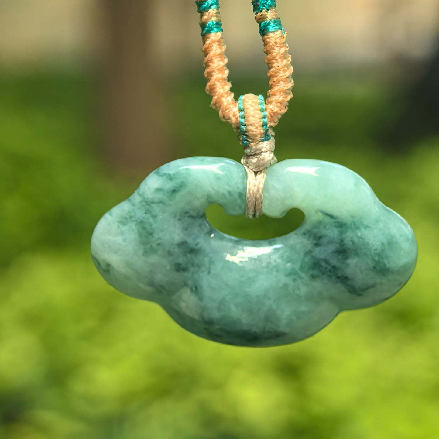 Natural Grade-A glutinous light green jadeite auspicious cloud pendant hanging on cord.
