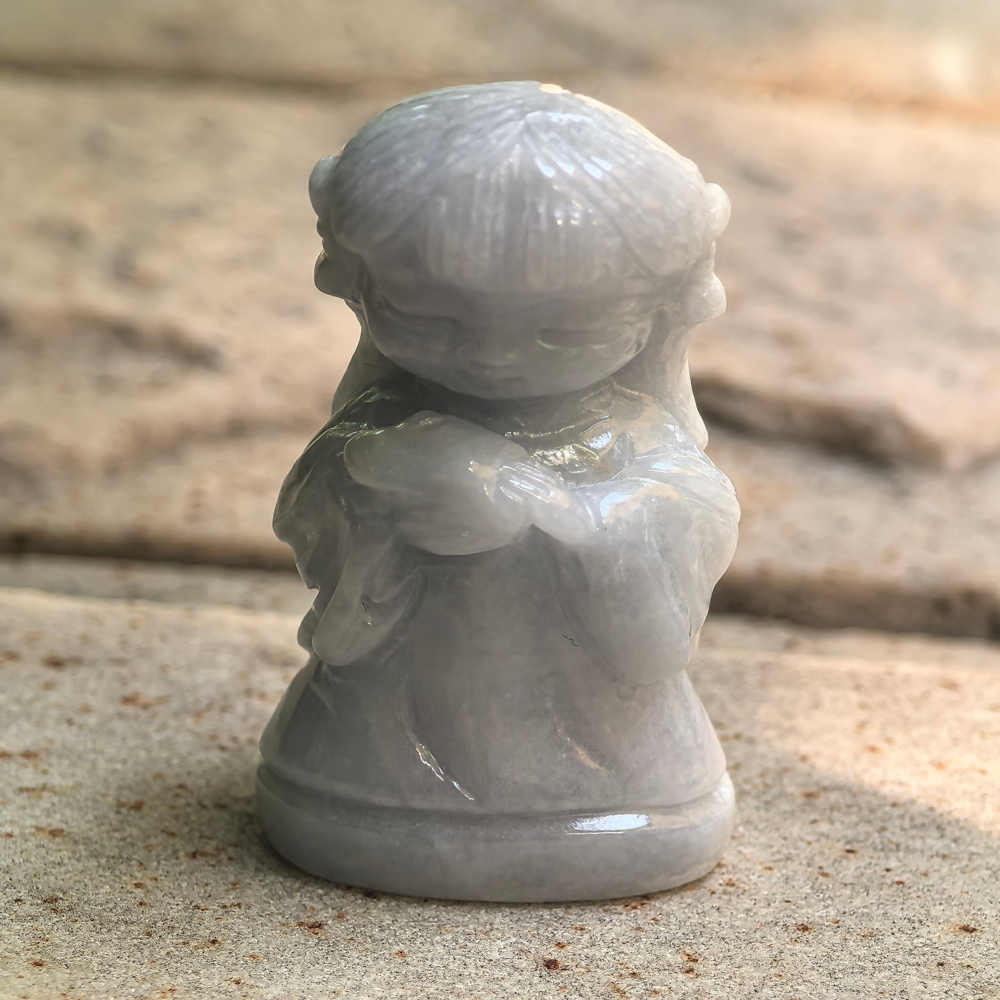 Natural Grade-A glutinous white and light green Chang'e jadeite ornament shown standing on stone.
