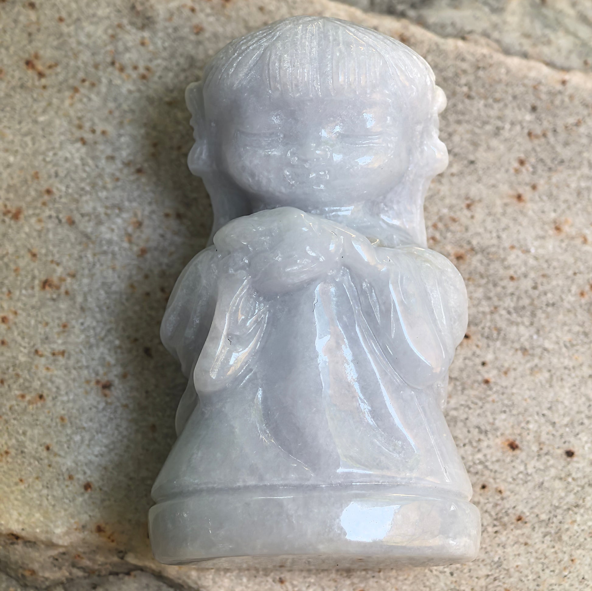 Close-up of glutinous white Chang'e jadeite ornament showing flowing robe carving and soft luster.
