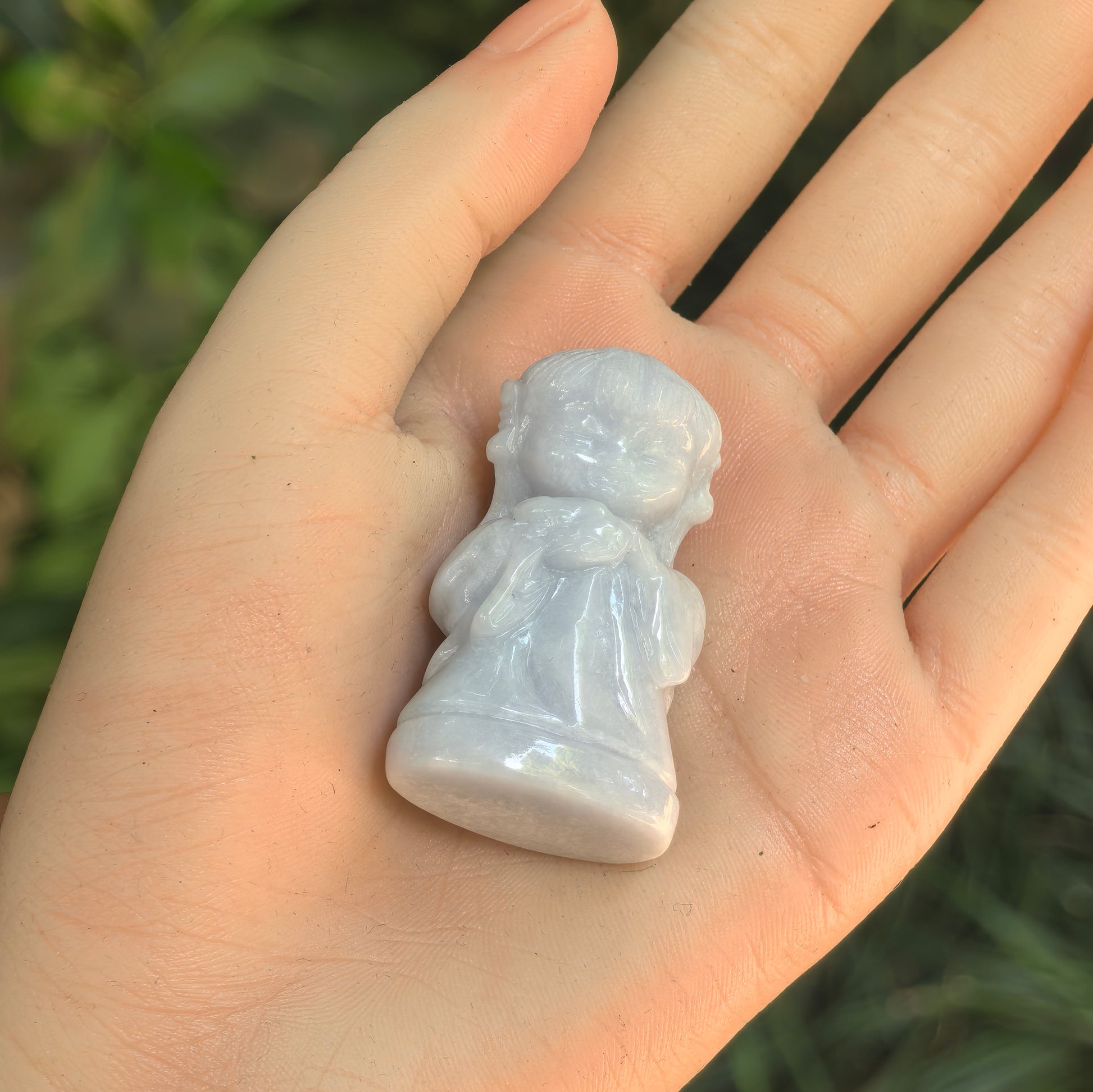Back view of natural Grade-A Chang'e jadeite ornament with pale green tone displayed in hand.
