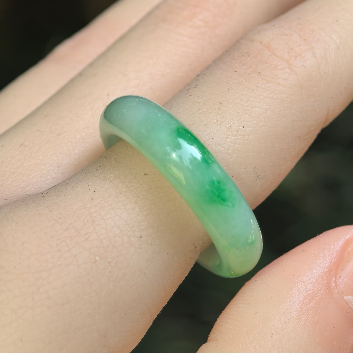 Natural Grade-A glutinous light green floating-flower jadeite ring band worn on finger.
