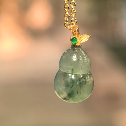 Natural Grade-A icy glutinous green floating flower gourd jadeite pendant with 18K gold bail.
