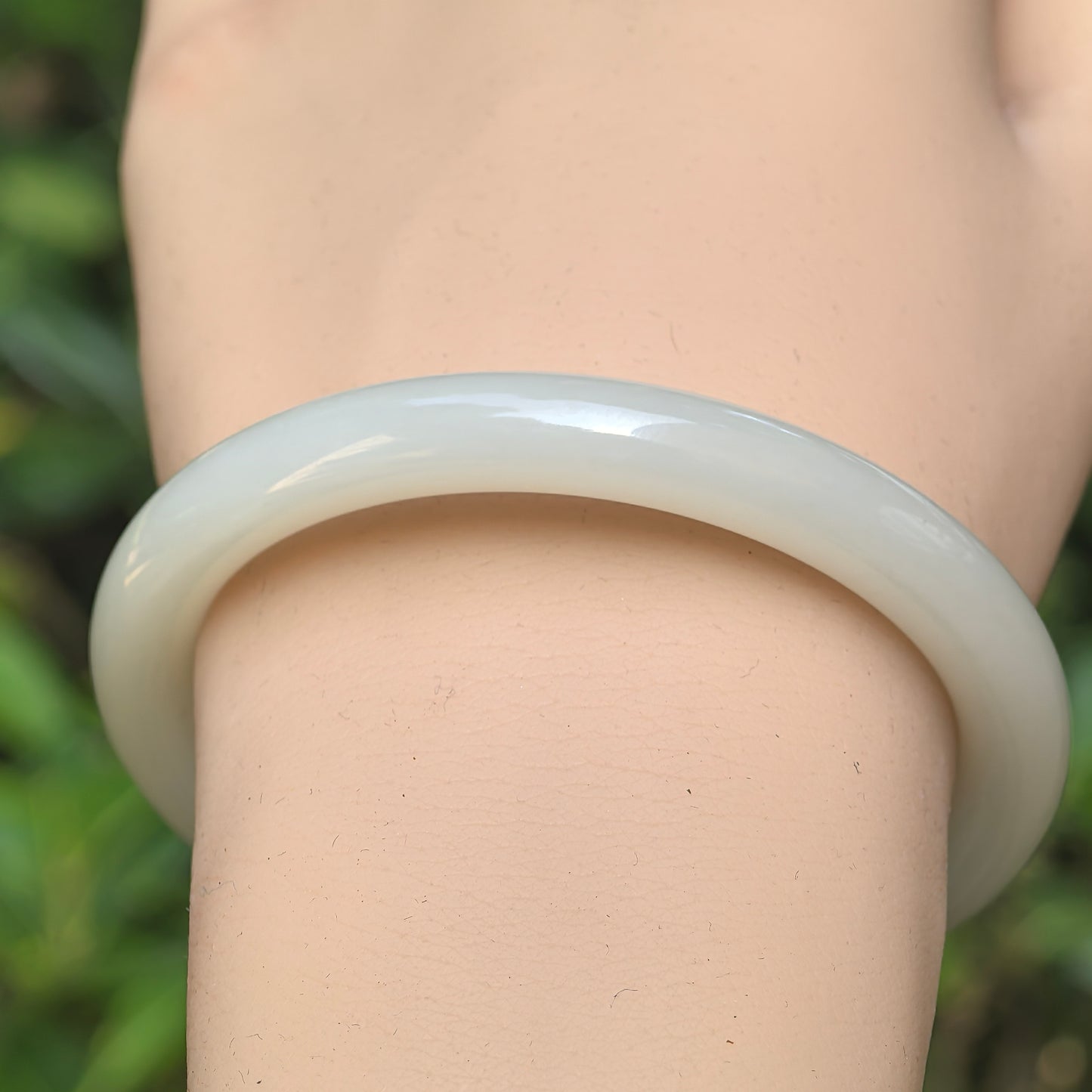Close-up of Qinghai Hetian white jade bangle showing fine texture and glossy surface.
