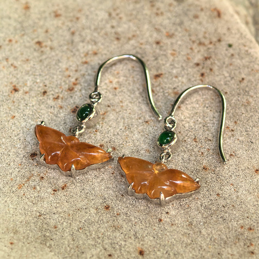 Close-up of icy honey yellow butterfly jadeite earrings with 18K gold hook setting.
