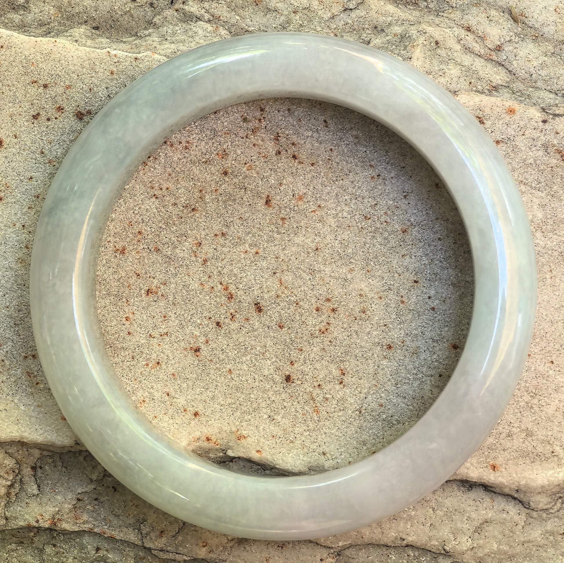 Top view of Natural Grade-A pale green jadeite bangle showing circular form and even polish.
