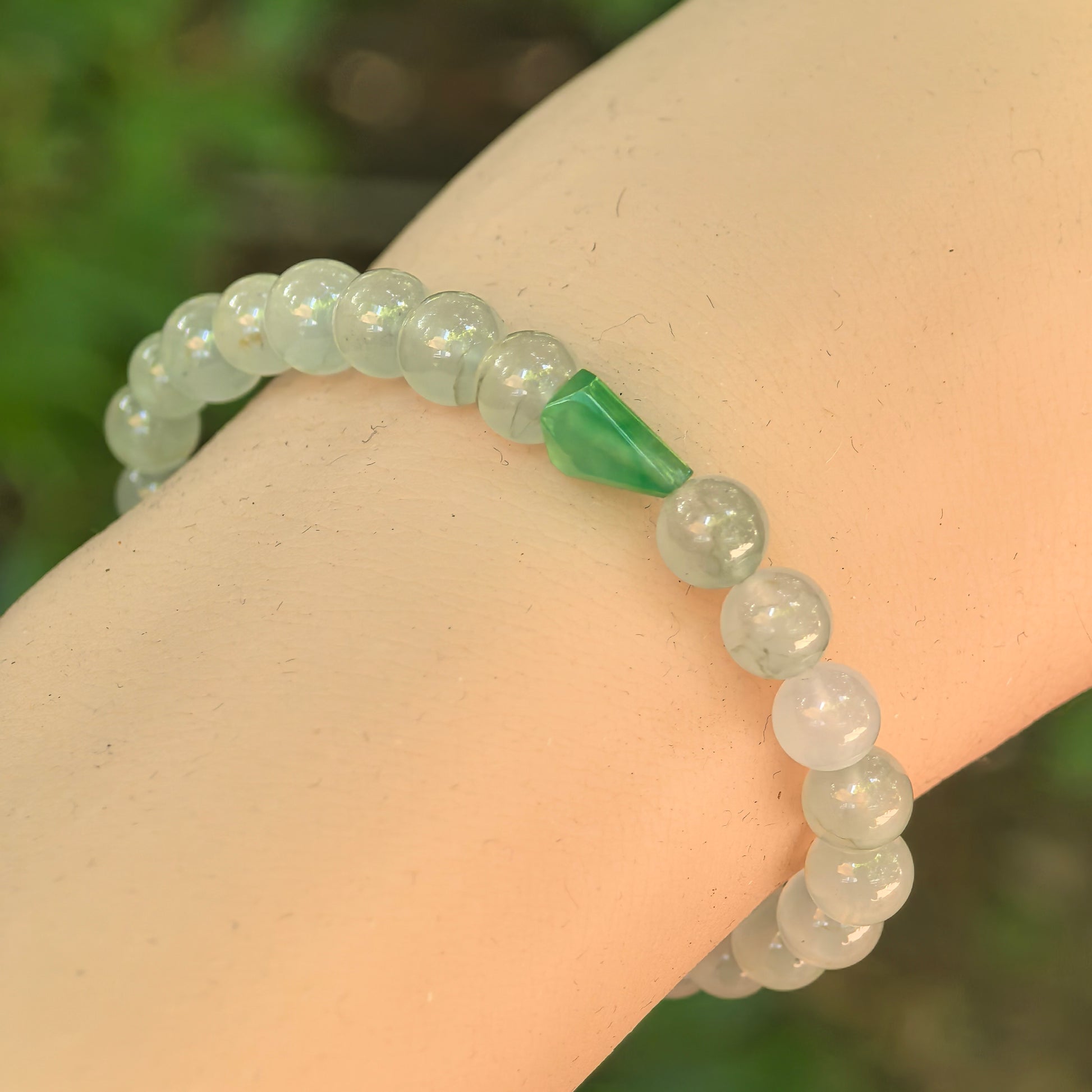 Natural Grade-A jadeite bead bracelet with 27 round beads and one green freeform accent.
