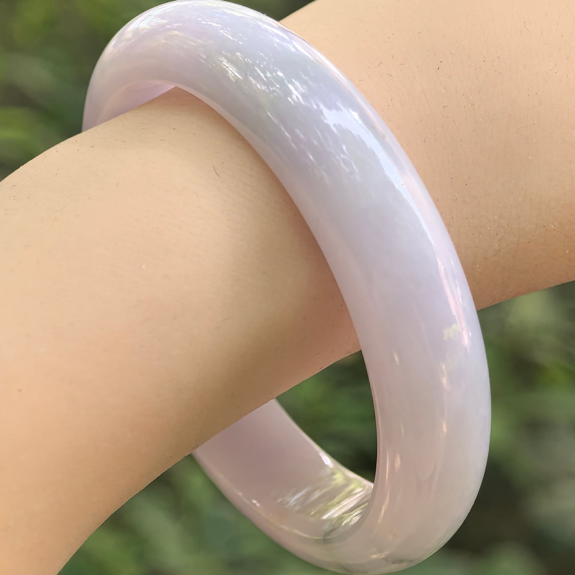 Natural Grade-A glutinous lavender jadeite D-shape bangle with subtle green accent worn on wrist.