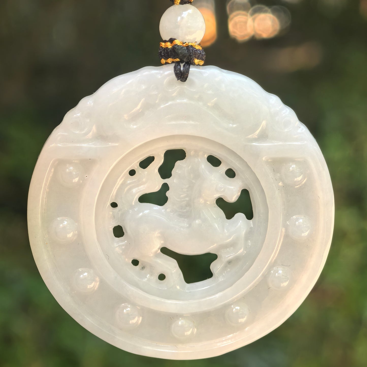 Natural Grade-A glutinous white jadeite rotating horse plaque pendant hanging on cord with openwork center design.