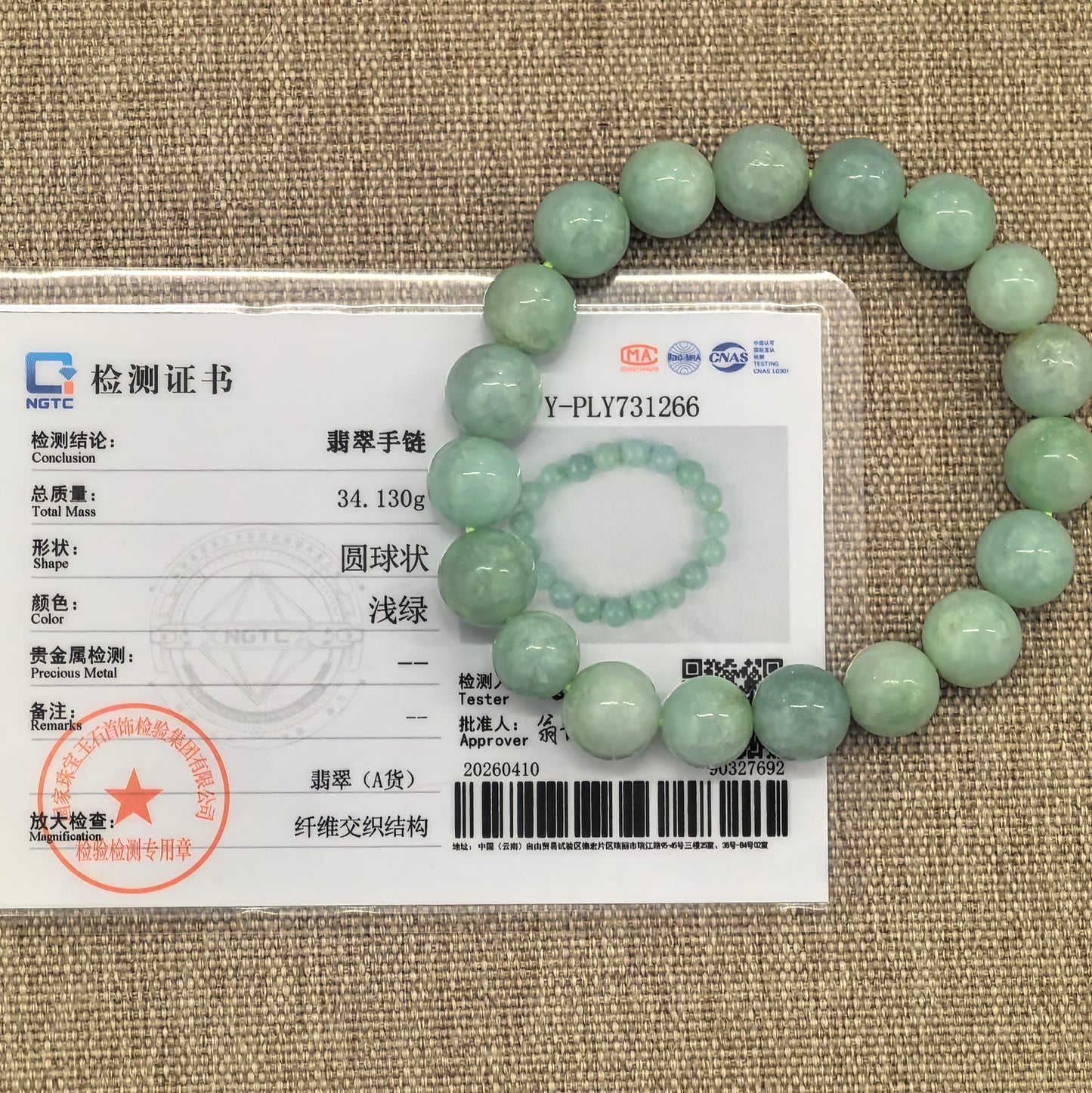 NGTC certified apple green jadeite bead bracelet shown with matching certificate.