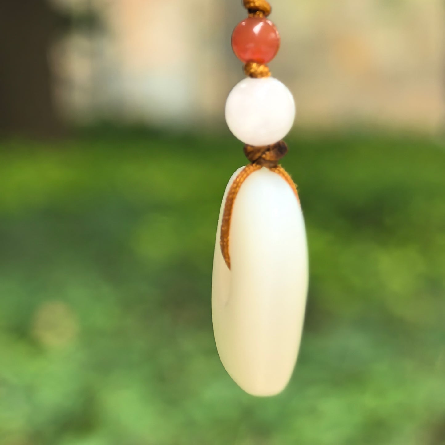 Side view of NGTC certified white Hetian jade square Peace Pendant showing smooth thickness and rounded edges.