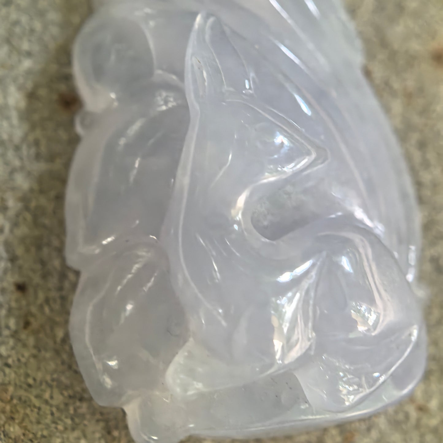 Close-up of NGTC certified lavender jadeite fox pendant showing layered tail carving and soft translucency.
