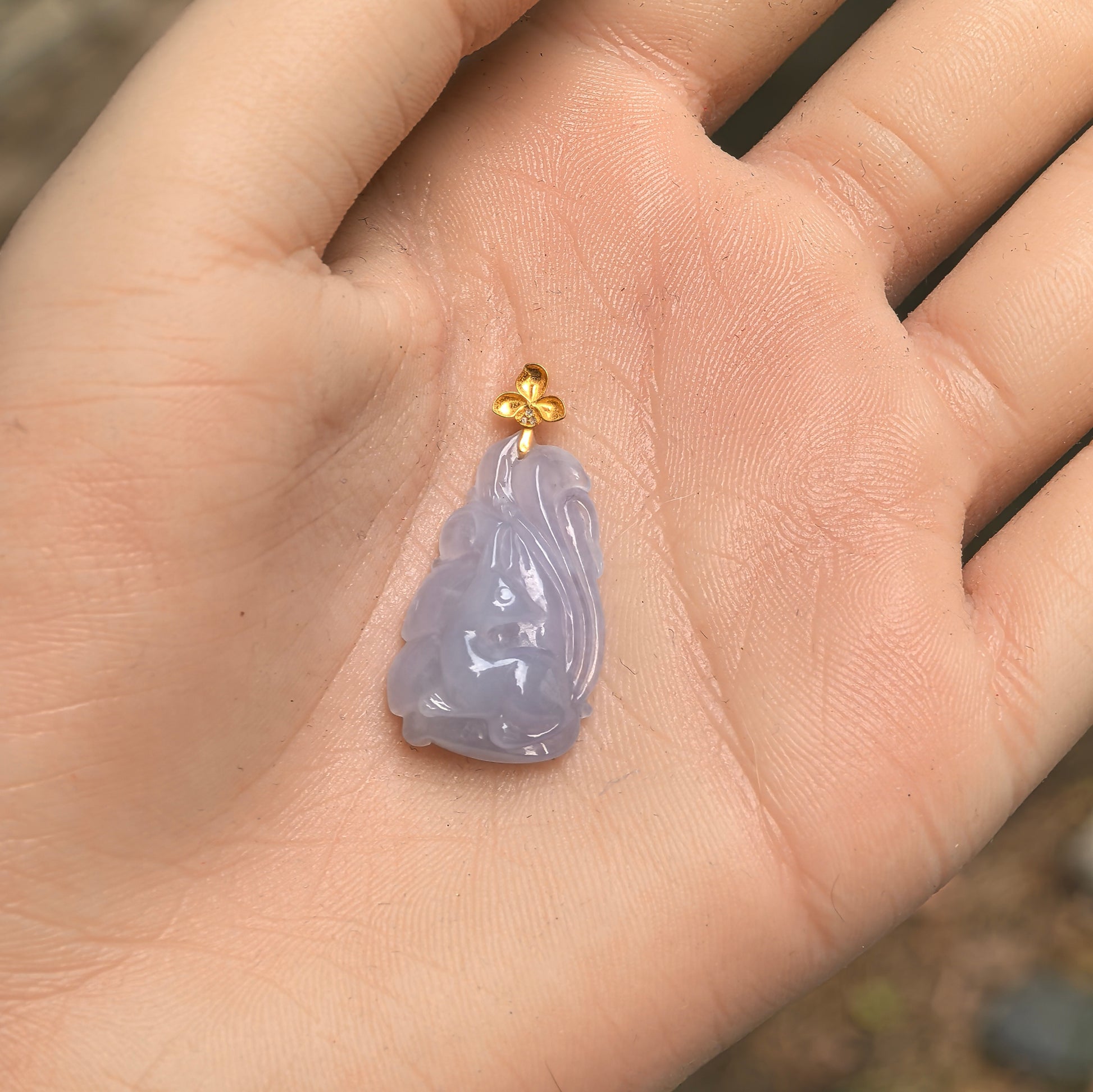 Small Natural Grade-A lavender nine-tailed fox jadeite pendant displayed in hand for scale.
