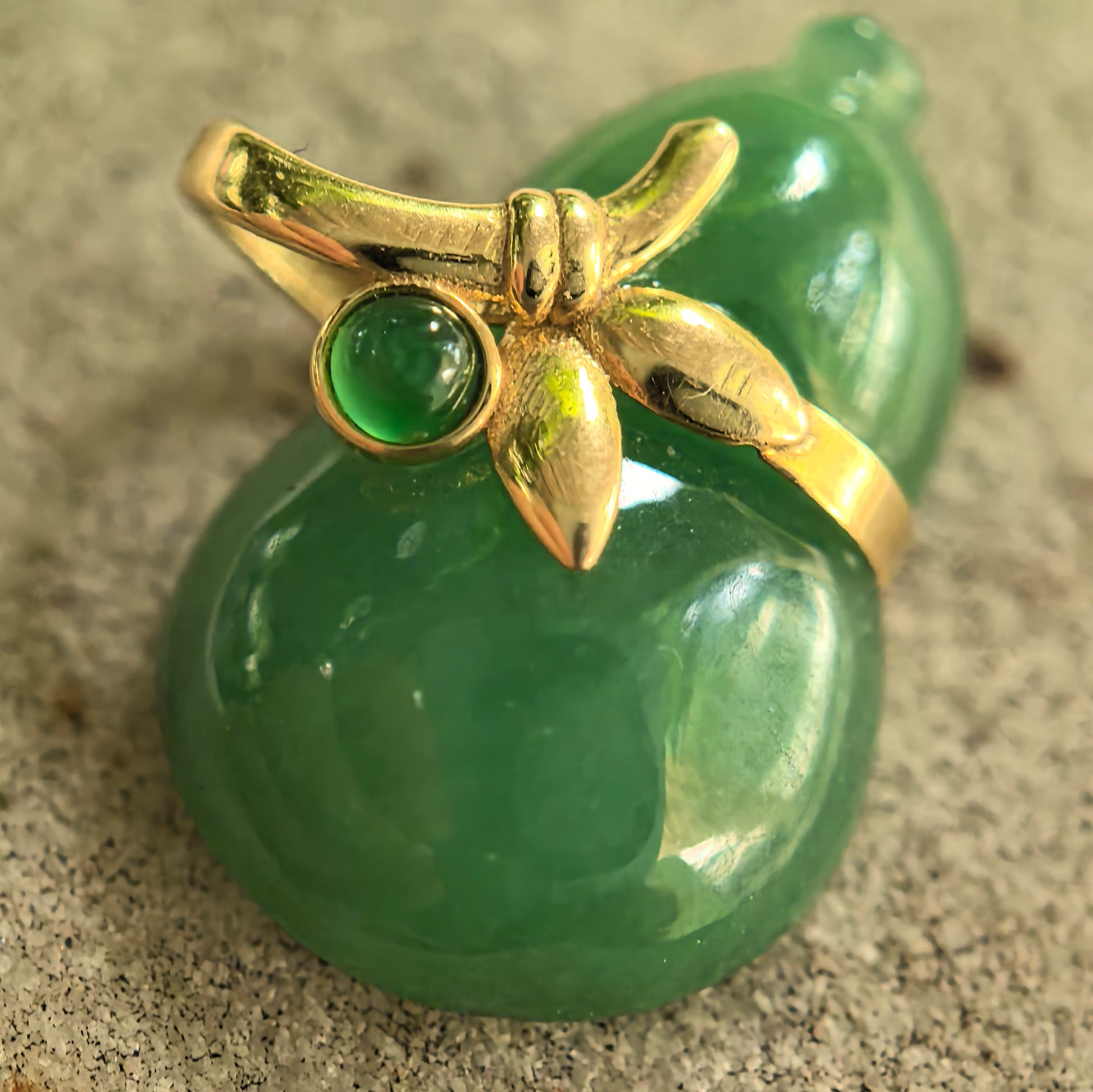 Close-up of 18K gold floral detail on natural Grade-A green gourd jadeite pendant.