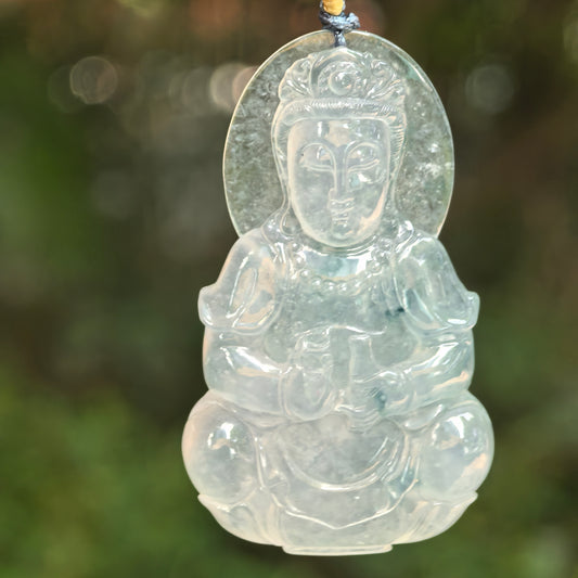 Close-up of light green white Guanyin jadeite pendant showing calm facial carving and halo detail.
