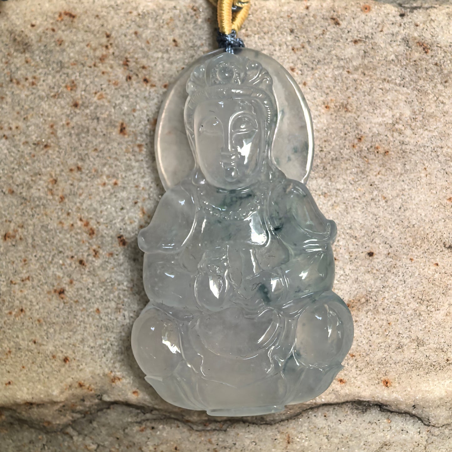 Icy glutinous Guanyin jadeite pendant with soft translucency and natural floating green areas.

