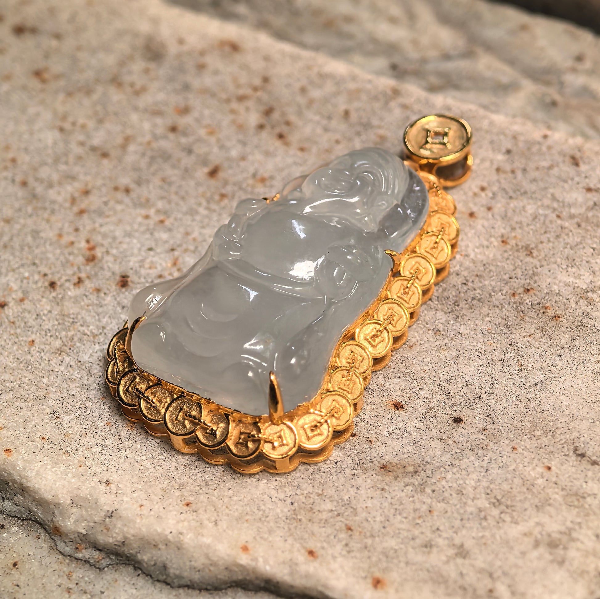 Side view of carved white jadeite pendant showing thickness, rounded carving, and 18K gold frame.