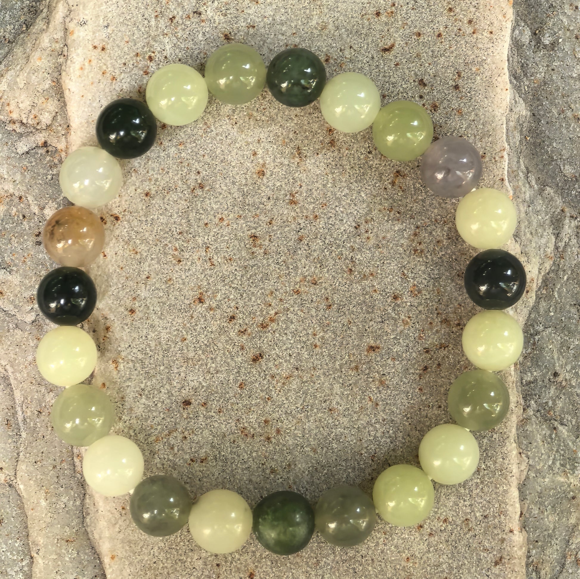 Angled view of multicolor Hetian jade round-bead bracelet arranged in an elastic bracelet style.
