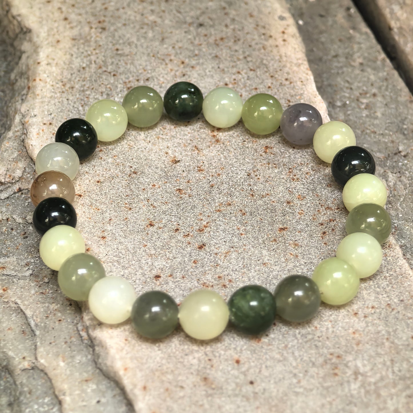 Assorted natural Hetian jade bead bracelet showing varied bead colors and polished round shapes.