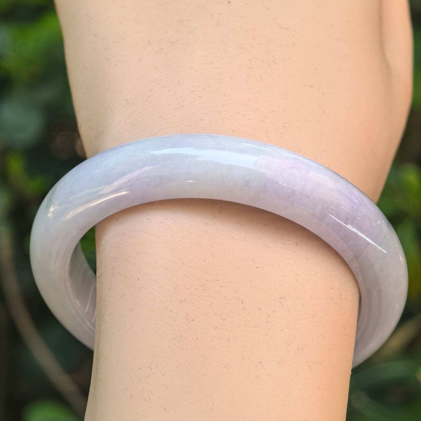 Close-up of pale lavender D-shape jadeite bangle showing soft luster and glutinous texture.