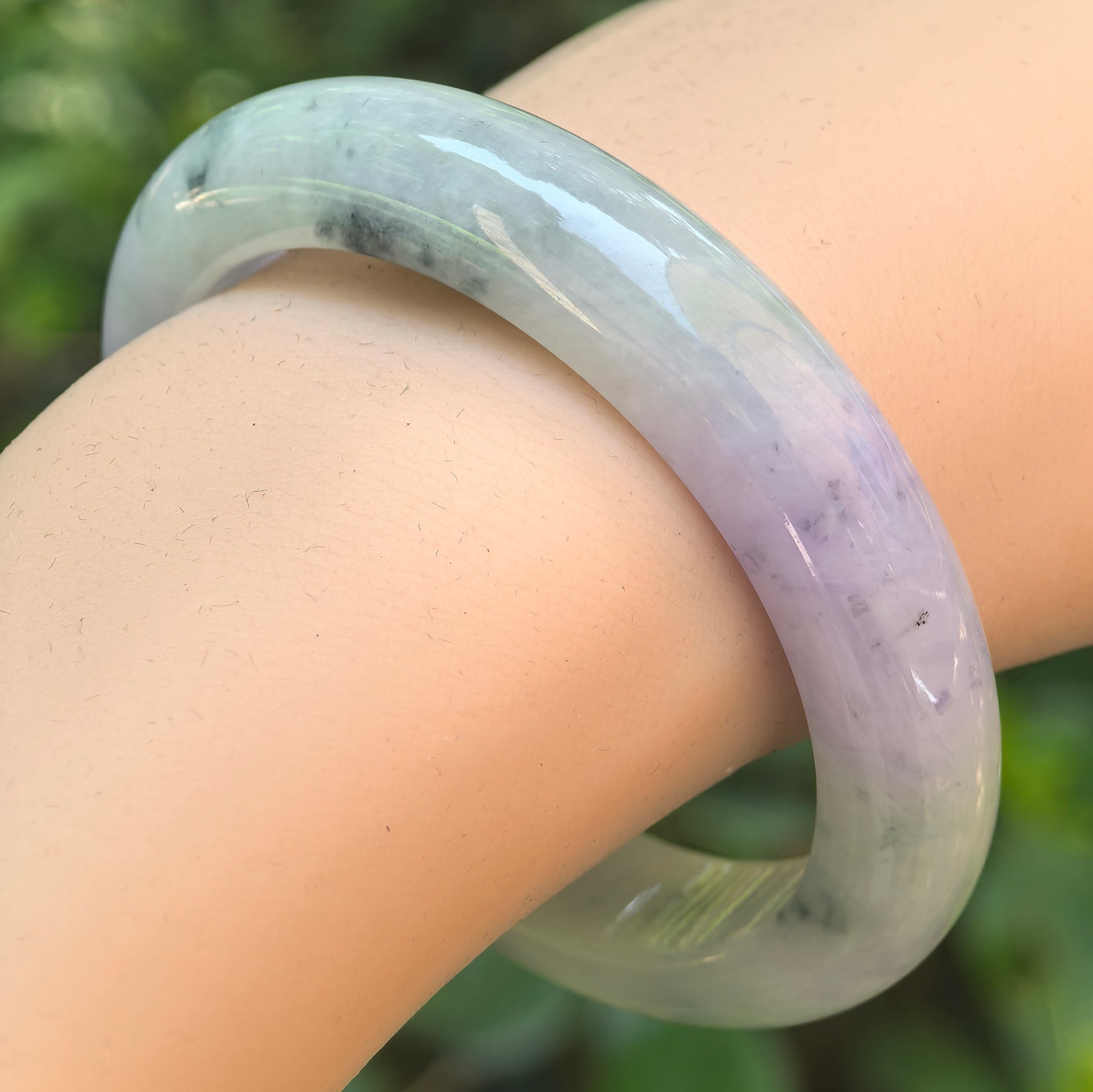 Natural Grade-A glutinous lavender green floral jadeite D-shape bangle worn on wrist.