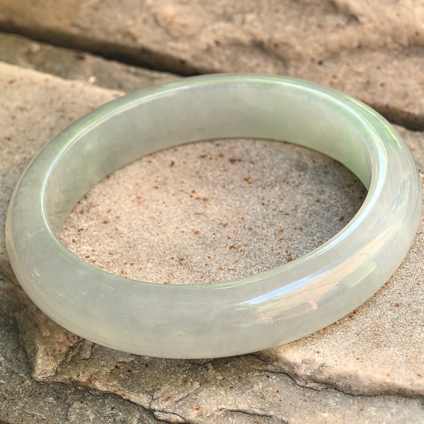 Natural Grade-A Longjing tea color jadeite bangle with D-shape profile and polished rounded surface.