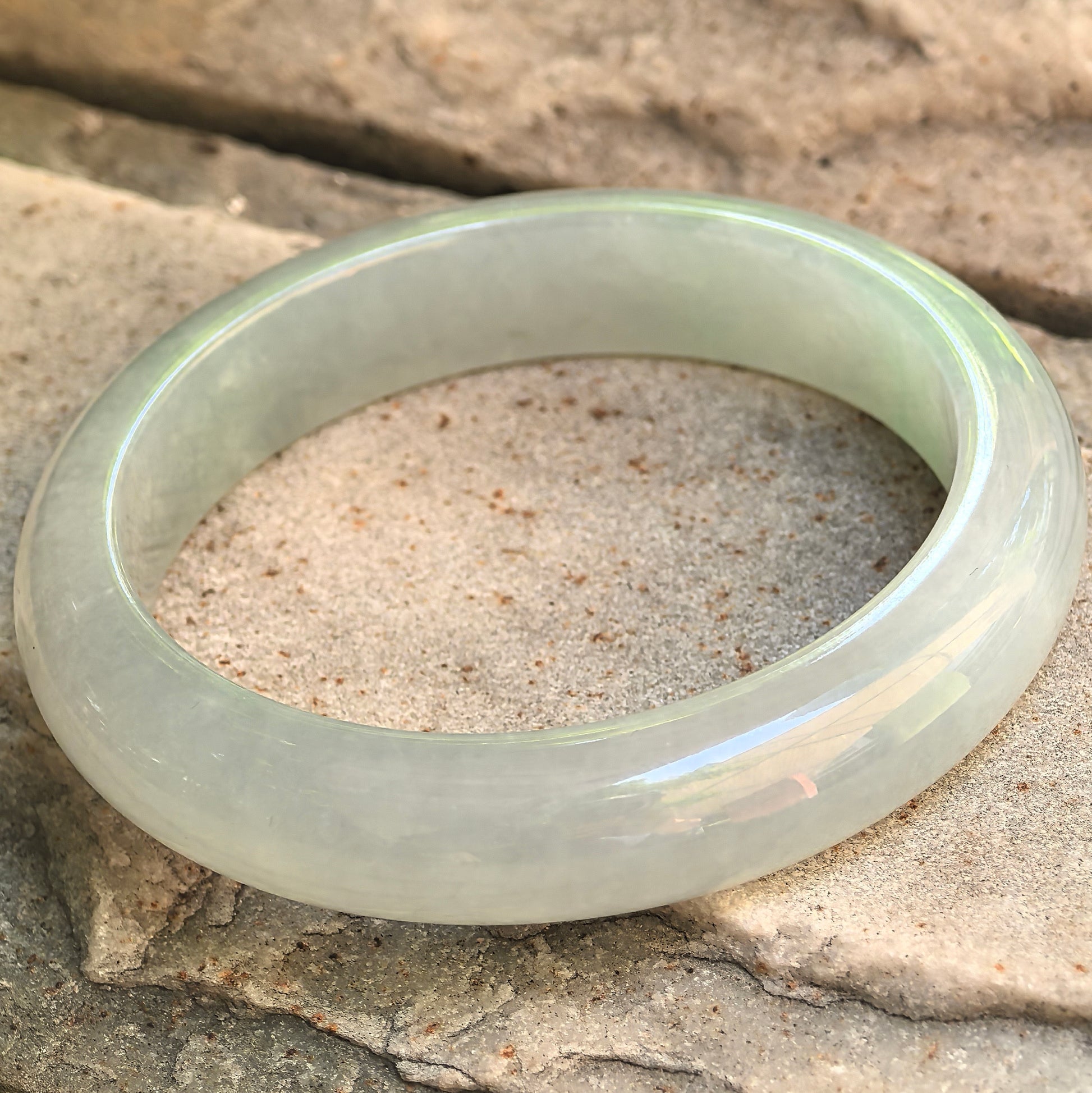 Natural Grade-A Longjing tea color jadeite bangle with D-shape profile and polished rounded surface.