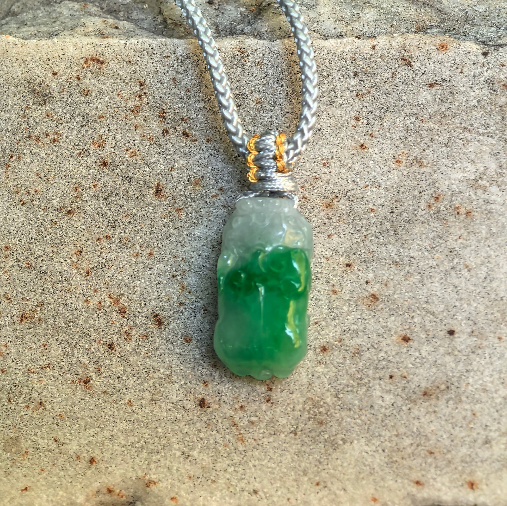 Front view of glutinous green Pixiu jadeite pendant showing compact carved details and soft luster.