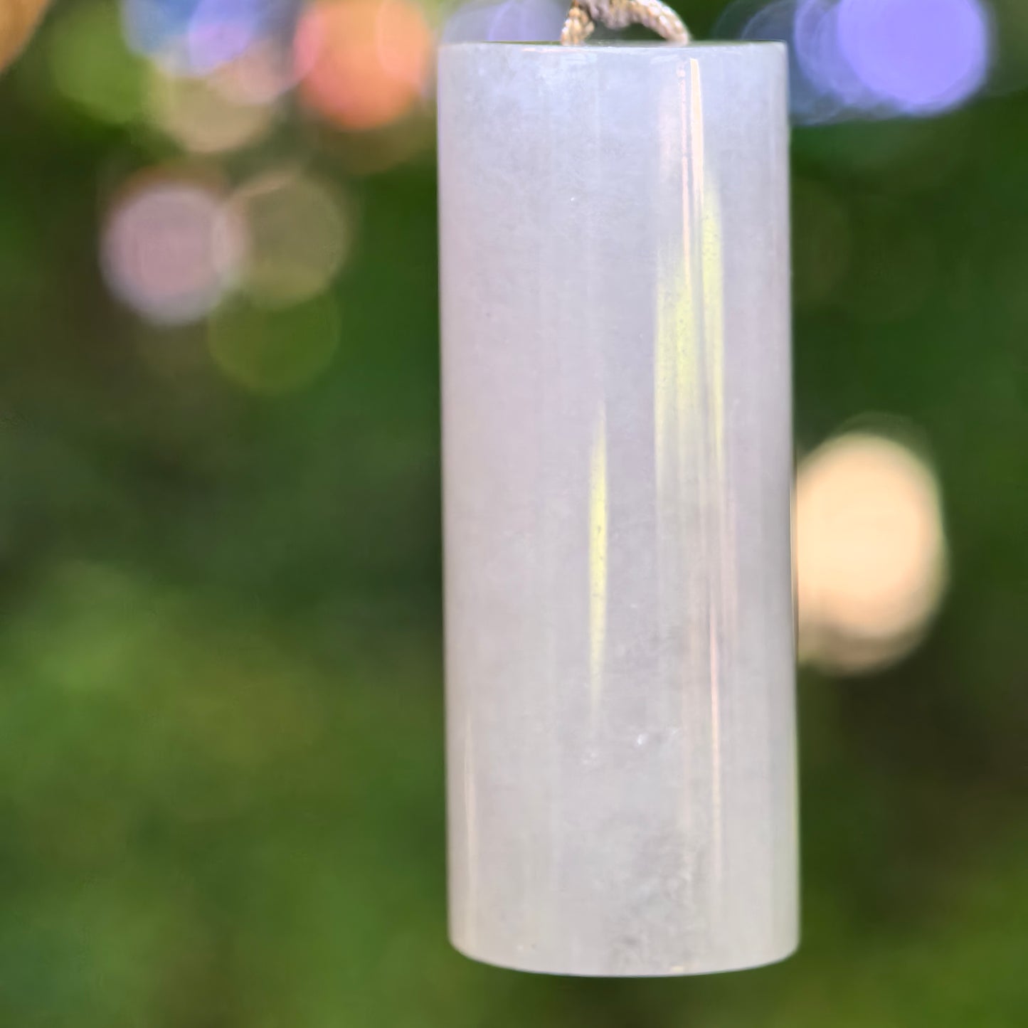 Natural Grade-A icy glutinous light purple plain pillar jadeite pendant hanging against a green background.
