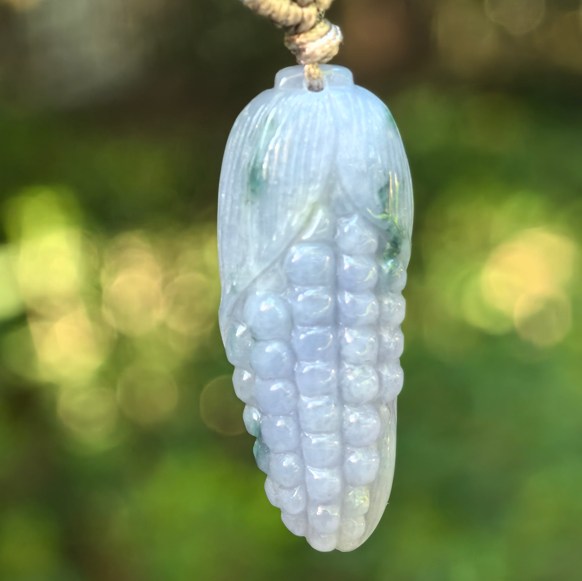 Natural Grade-A glutinous lavender-green corn jadeite pendant hanging on cord.
