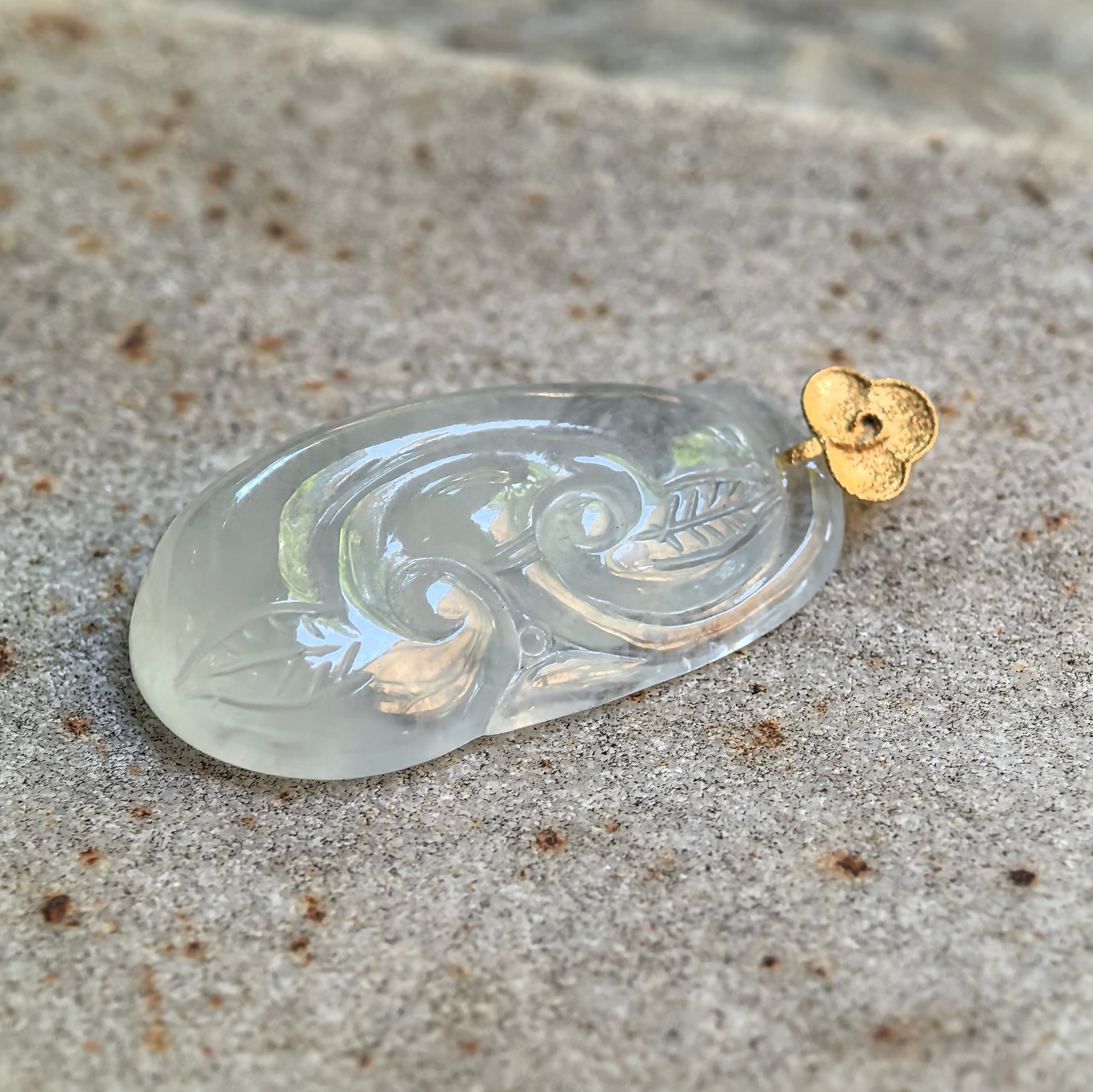 Side view of glutinous icy white jadeite Ruyi pendant showing rounded thickness and translucency.