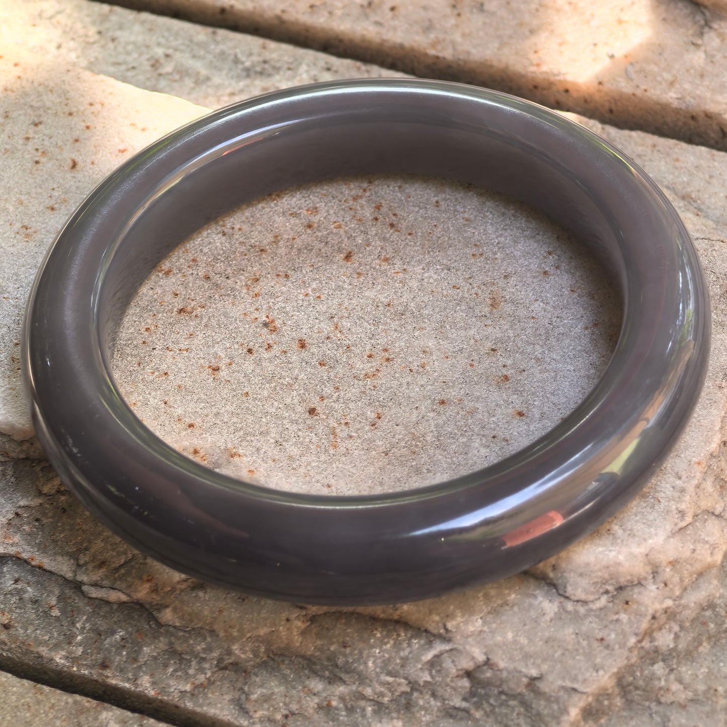 Side view of deep smoky purple Hetian jade bangle showing 12 mm width and rounded outer profile.