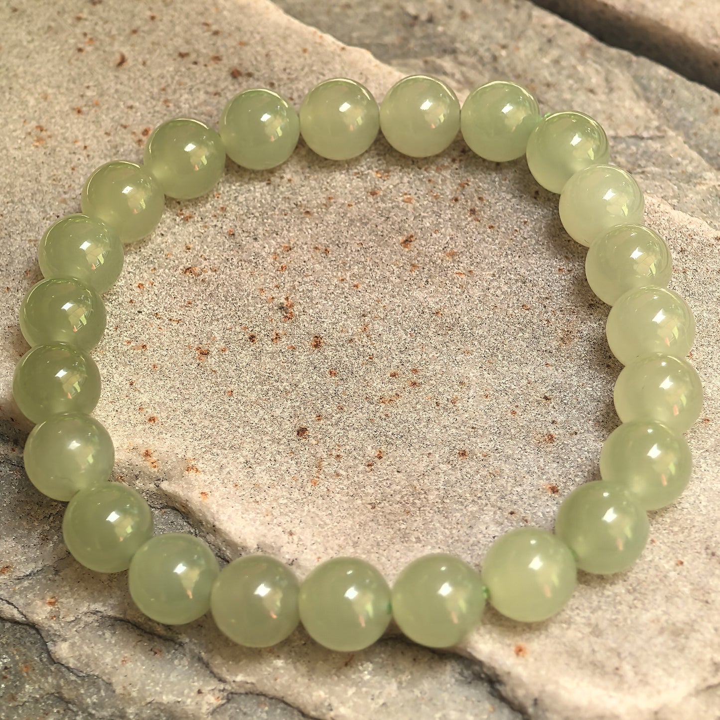 Celadon green nephrite elastic bead bracelet showing soft natural tonal variation.