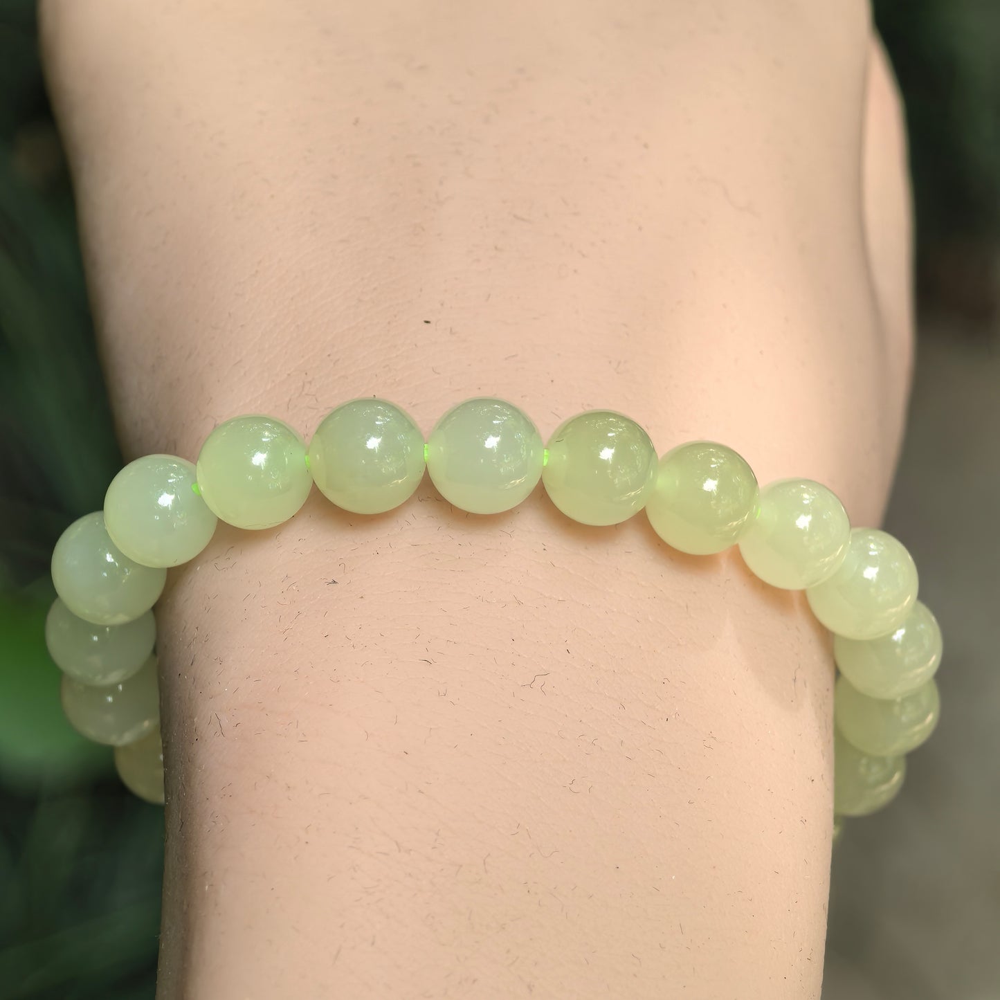 Close-up of yellow nephrite round bead bracelet with glossy polished surface.