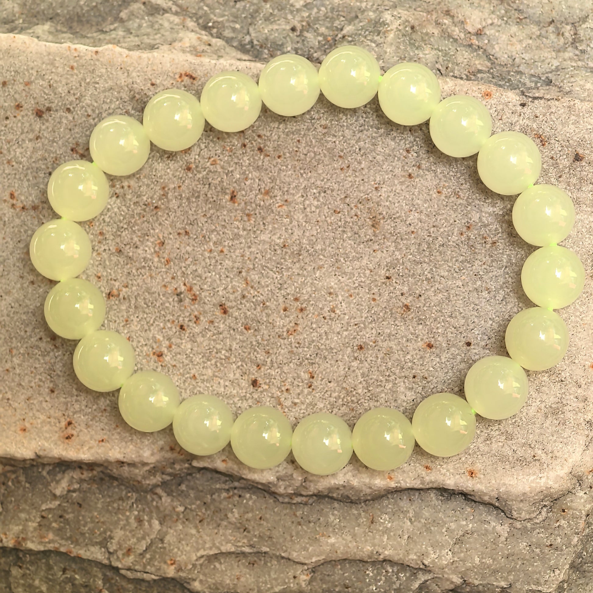 Natural Hetian jade bracelet with yellow 8mm beads displayed on stone background.