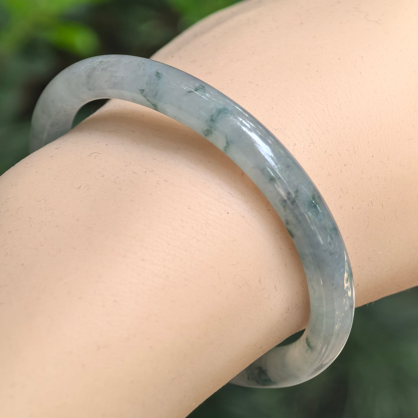 Natural Grade-A glutinous-icy green floating flower oval jadeite bangle worn on the wrist.