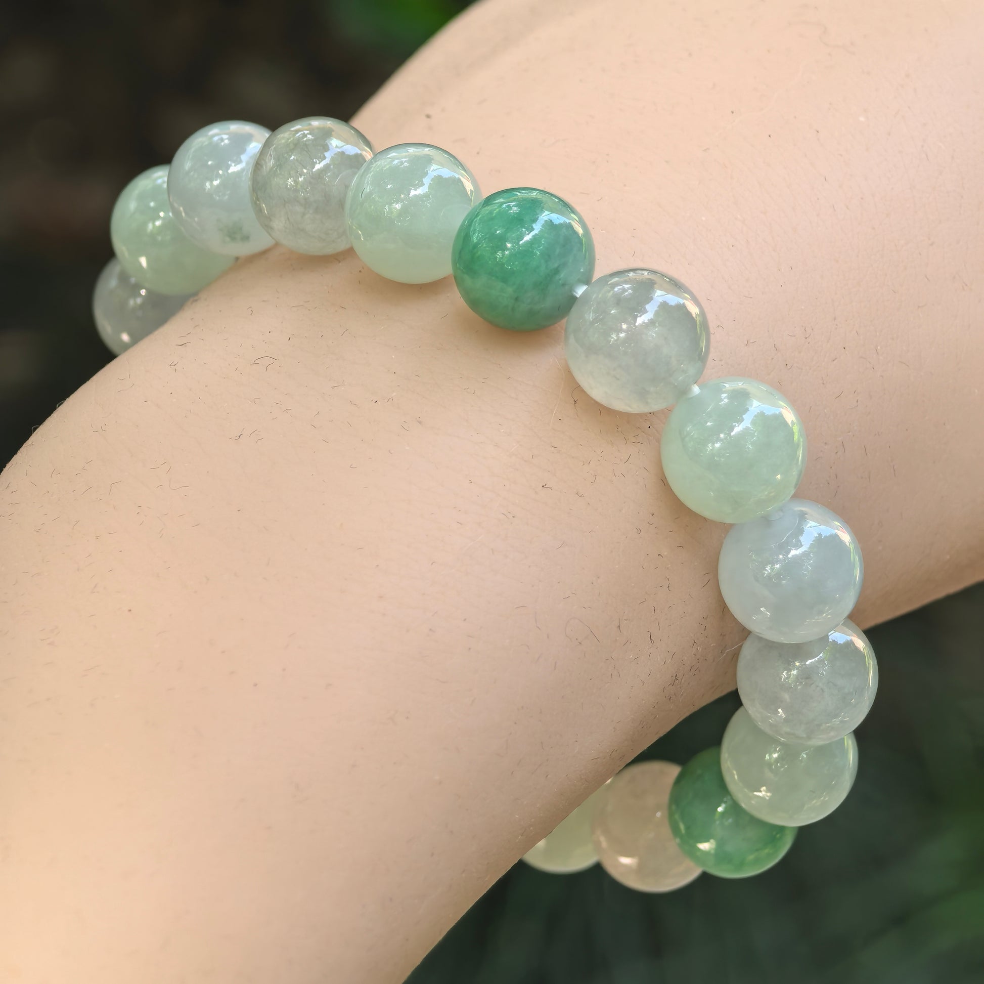 Natural Grade-A glutinous-icy light green jadeite bead bracelet worn on wrist.