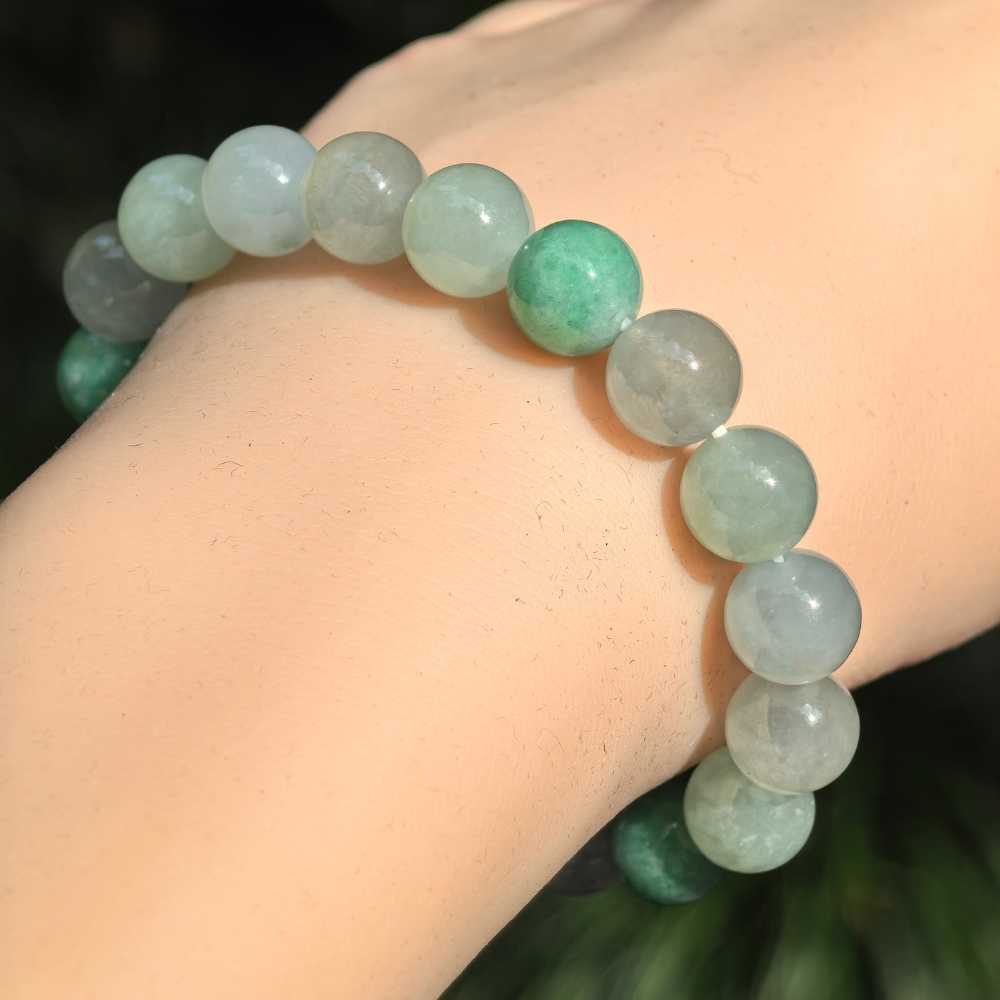 Glutinous-icy light green jadeite bracelet showing soft translucency and glossy polish.