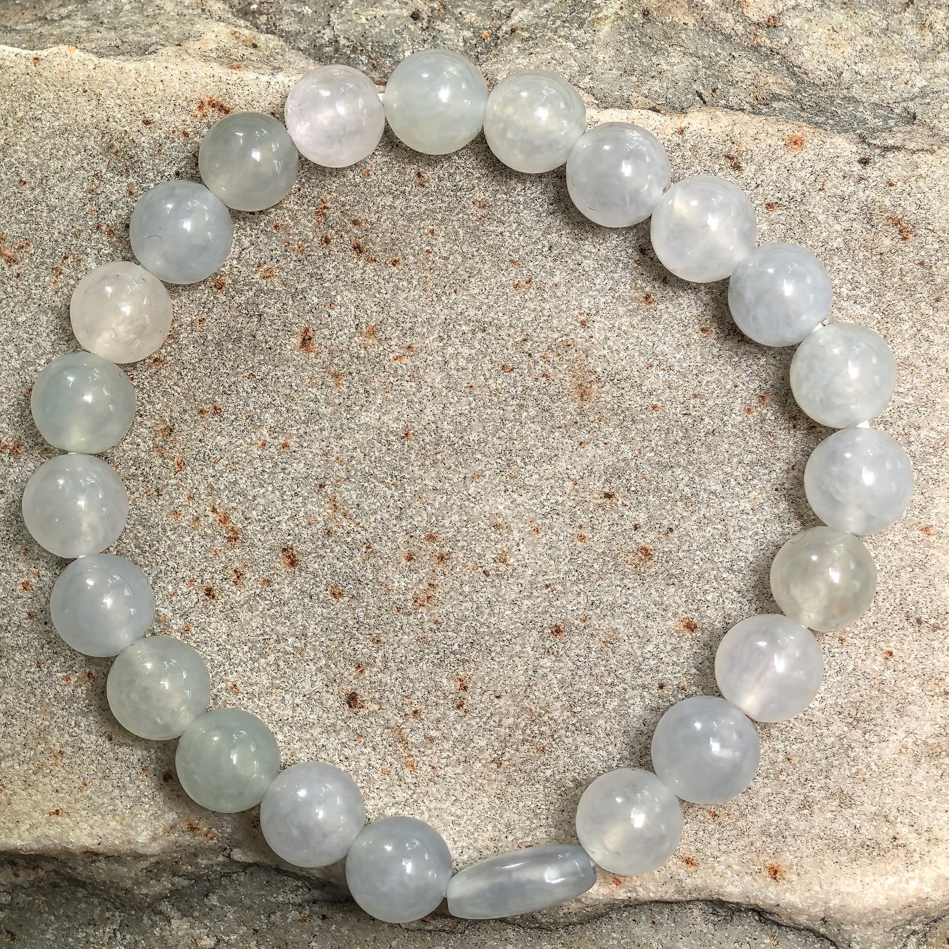Natural jadeite bracelet with round beads and one barrel-shaped accent bead.