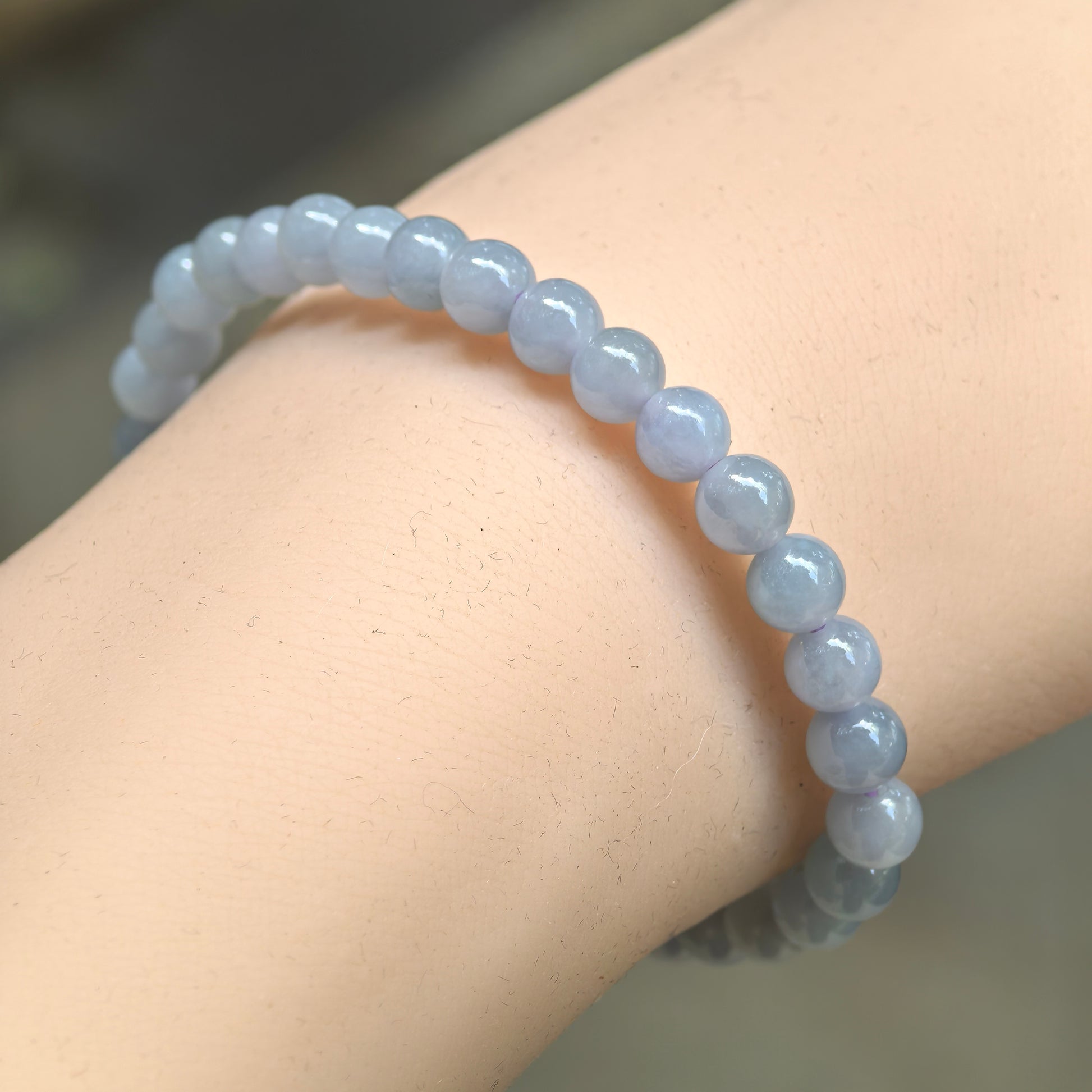 Natural Grade-A glutinous-icy blue-purple jadeite bead bracelet worn on wrist.