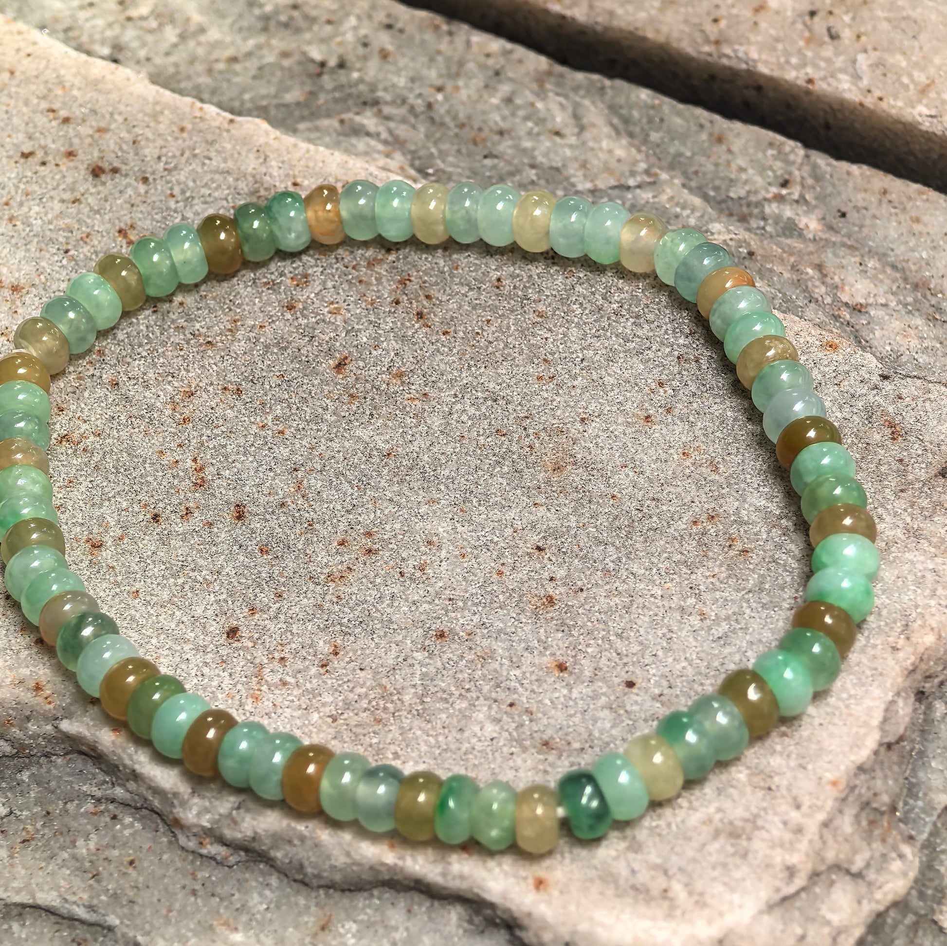 Glutinous-icy multicolor jadeite bead bracelet showing soft translucency and glossy polish.