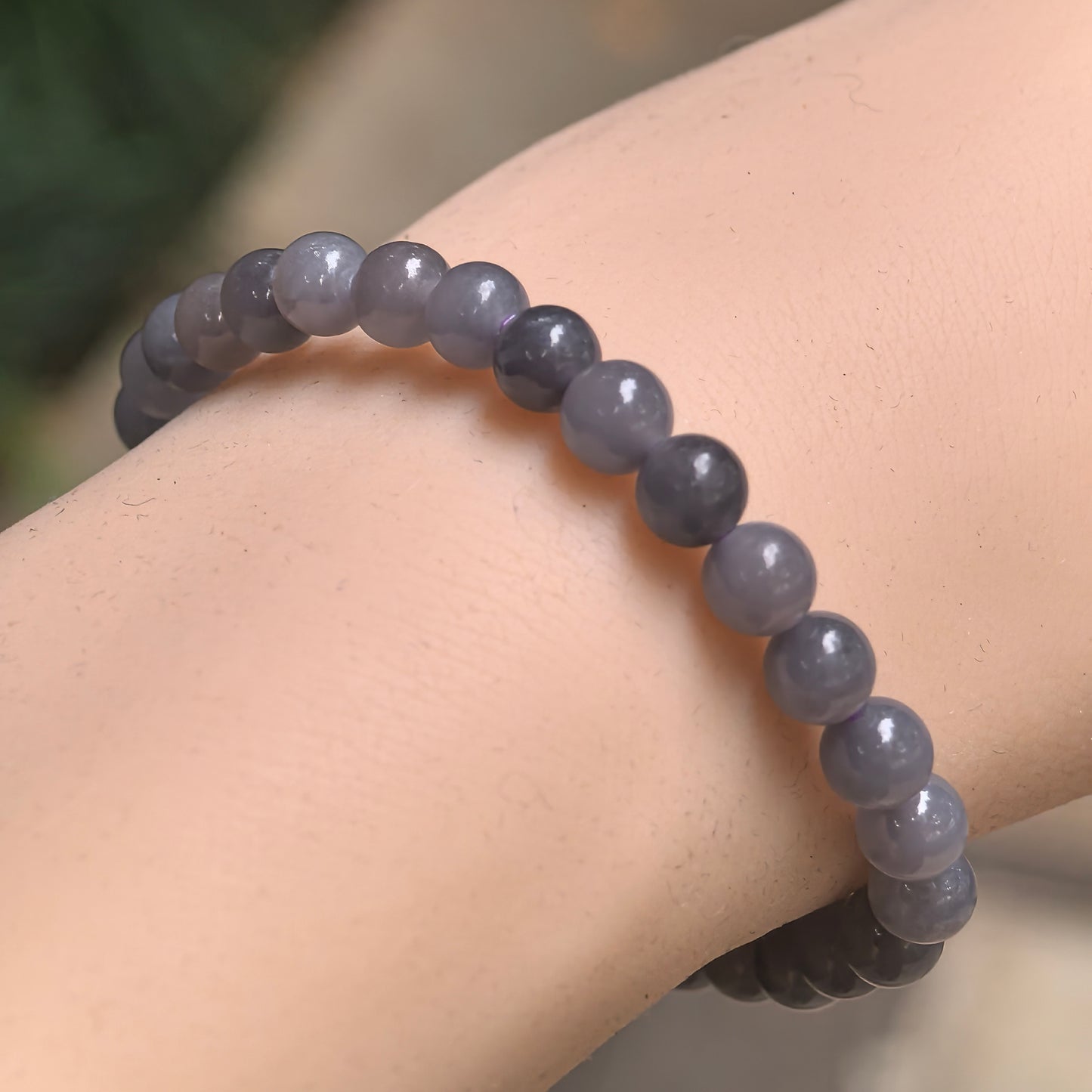 Natural smoky purple Hetian jade 6mm bead bracelet worn on wrist.