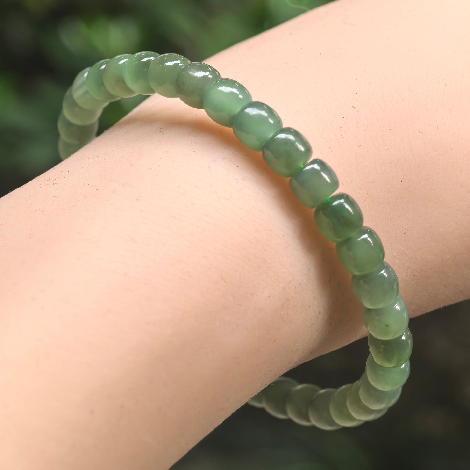 Natural green Hetian jade abacus bead bracelet worn on wrist.