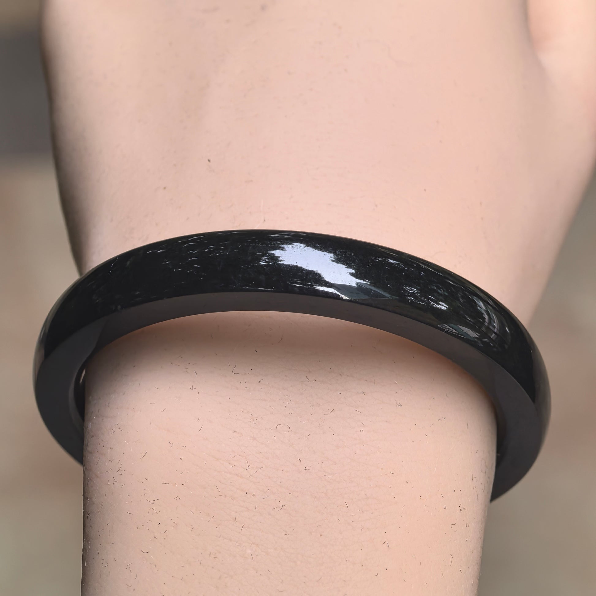 Close-up of near-black Hetian jade bangle showing very deep green color and smooth luster.