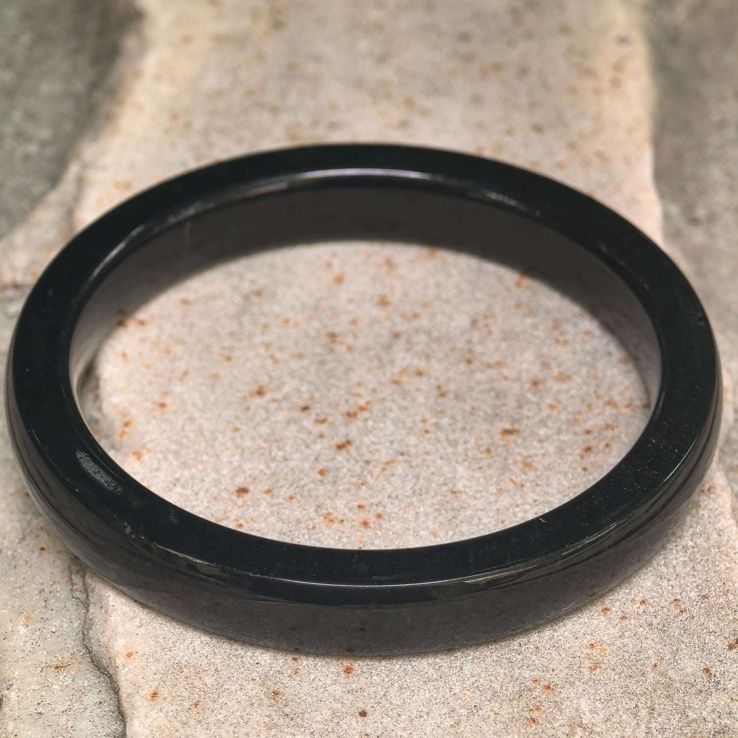 Side view of dark green Hetian jade bangle showing square profile and slim thickness.