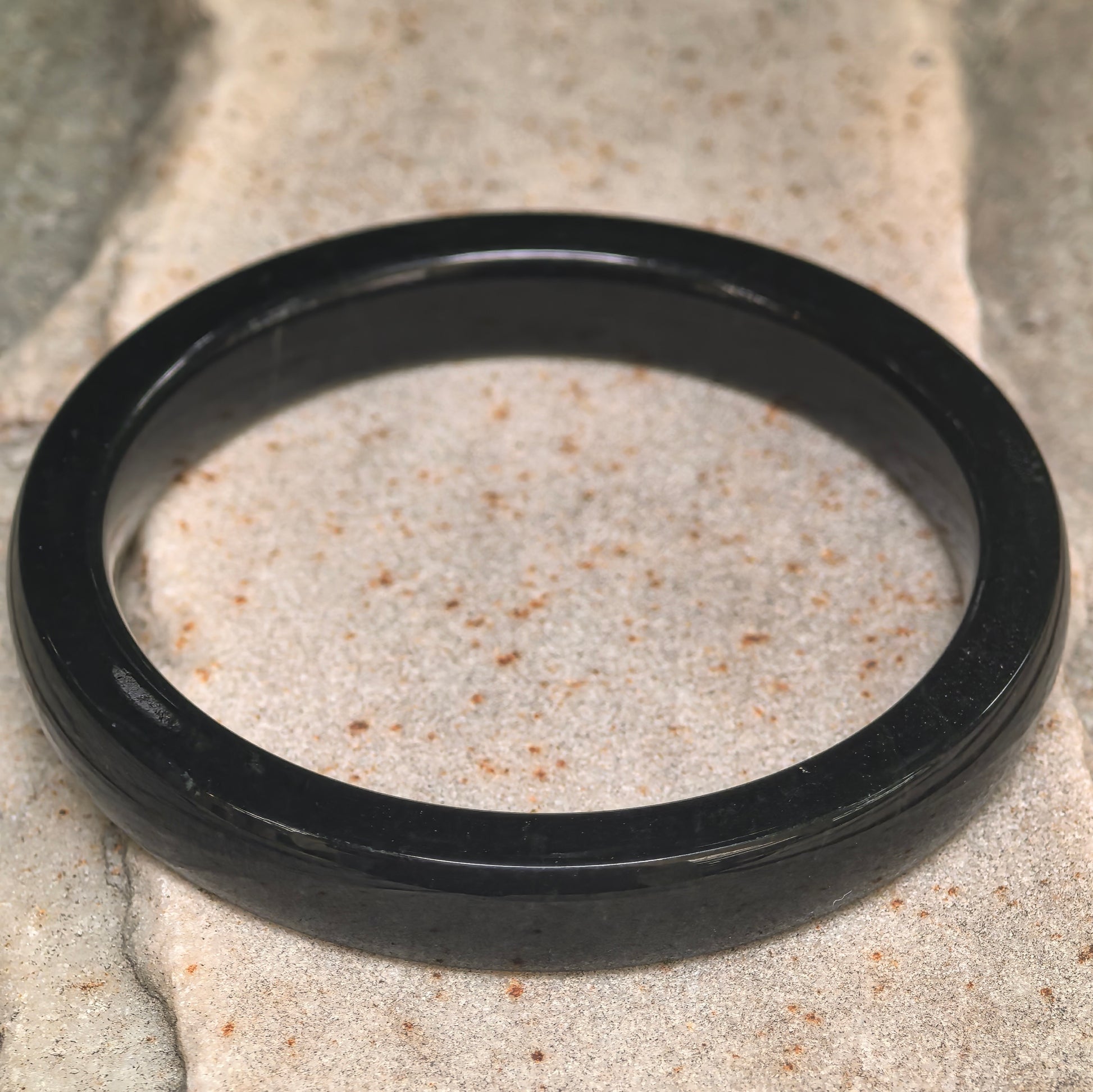 Side view of dark green Hetian jade bangle showing square profile and slim thickness.