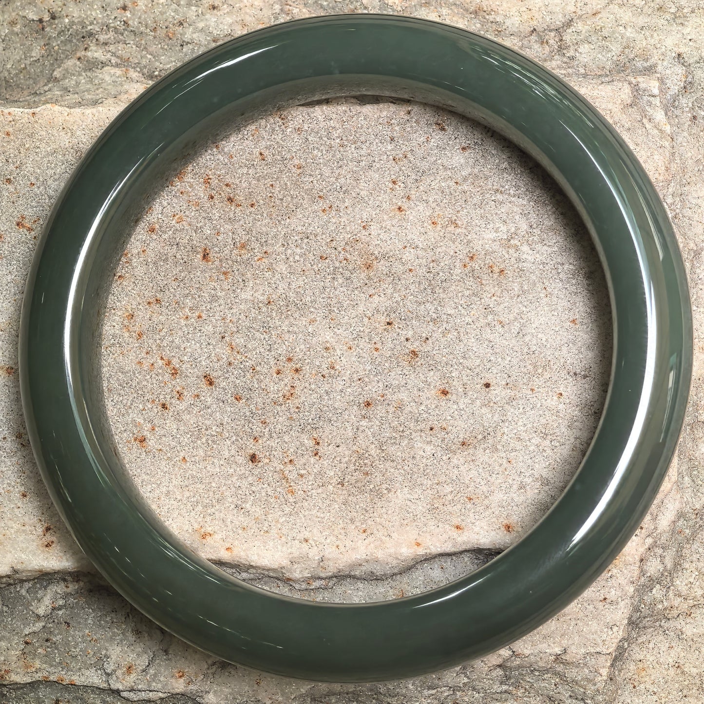 Top view of deep green Hetian jade bangle showing classic circular shape and even polish.