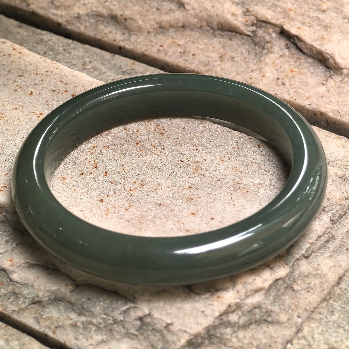 Side view of natural Hetian jade D-shape bangle showing approximately 11.5 mm width and rounded outer profile.